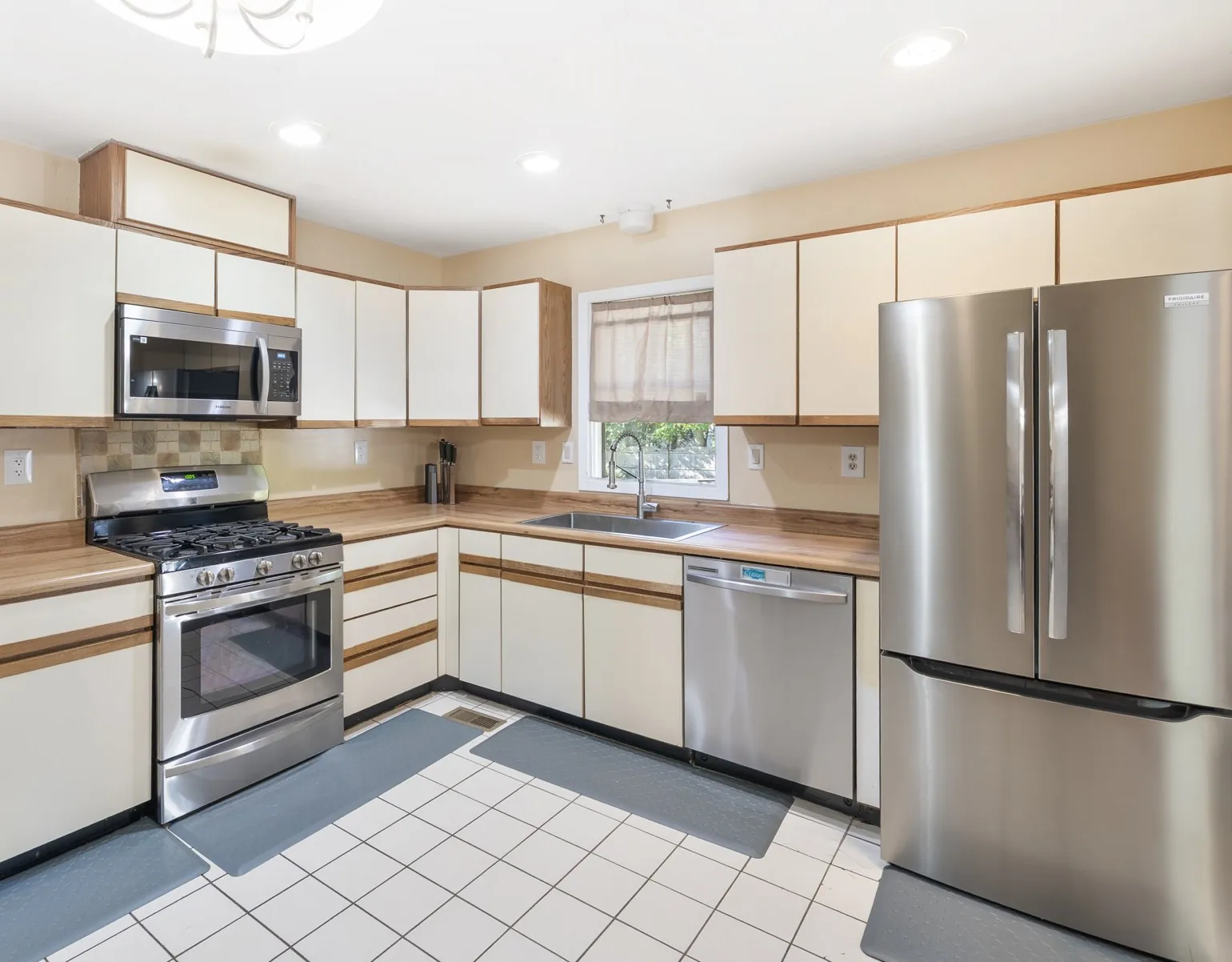Kitchen with stainless steel refrigerator, gas range and microwave